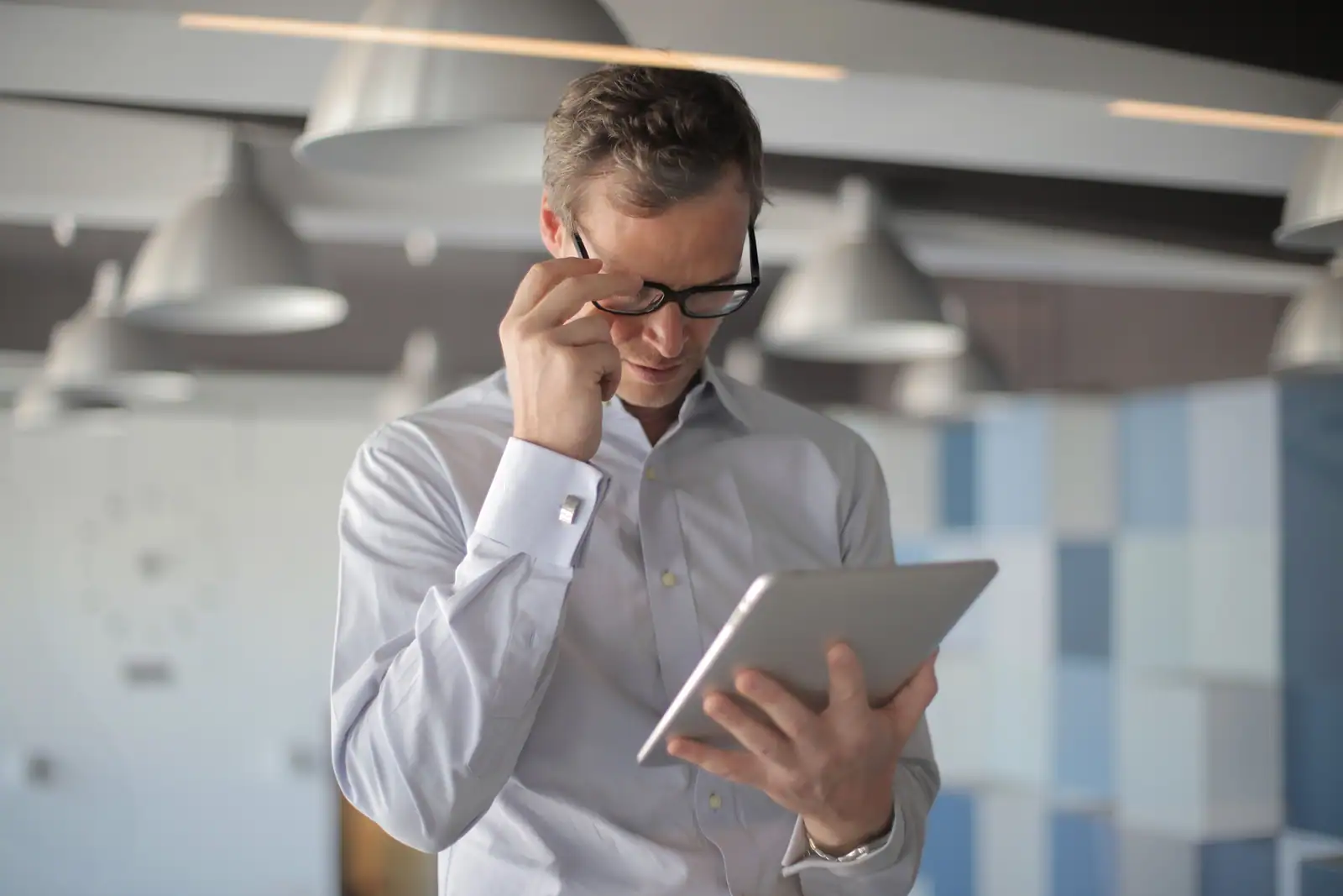 Personne lisant un article sur une tablette dans un bureau lumineux