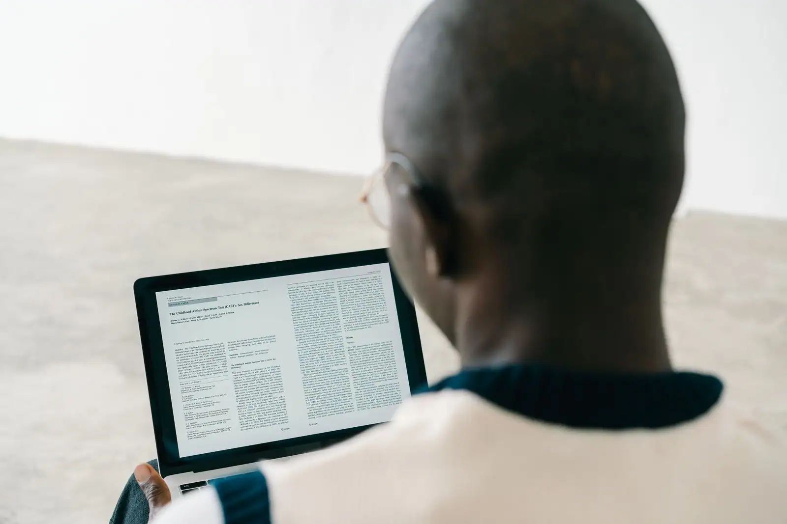 Personne lisant un article en ligne sur l'écran d'un ordinateur portable, à son bureau