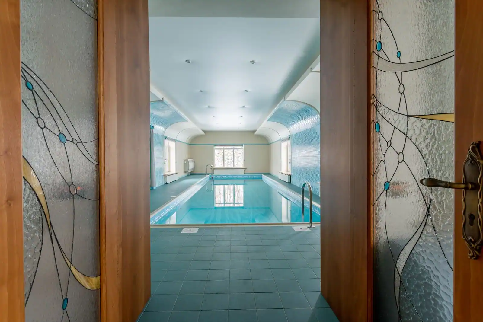 Piscine intérieure d'un hôtel-spa, eau calme et lumière tamisée, dans une ambiance propice à la détente