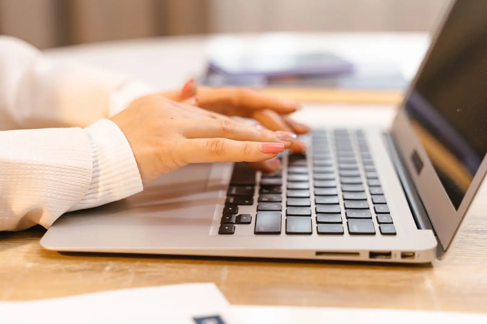 Mains tapant sur le clavier d'un ordinateur portable, en gros plan