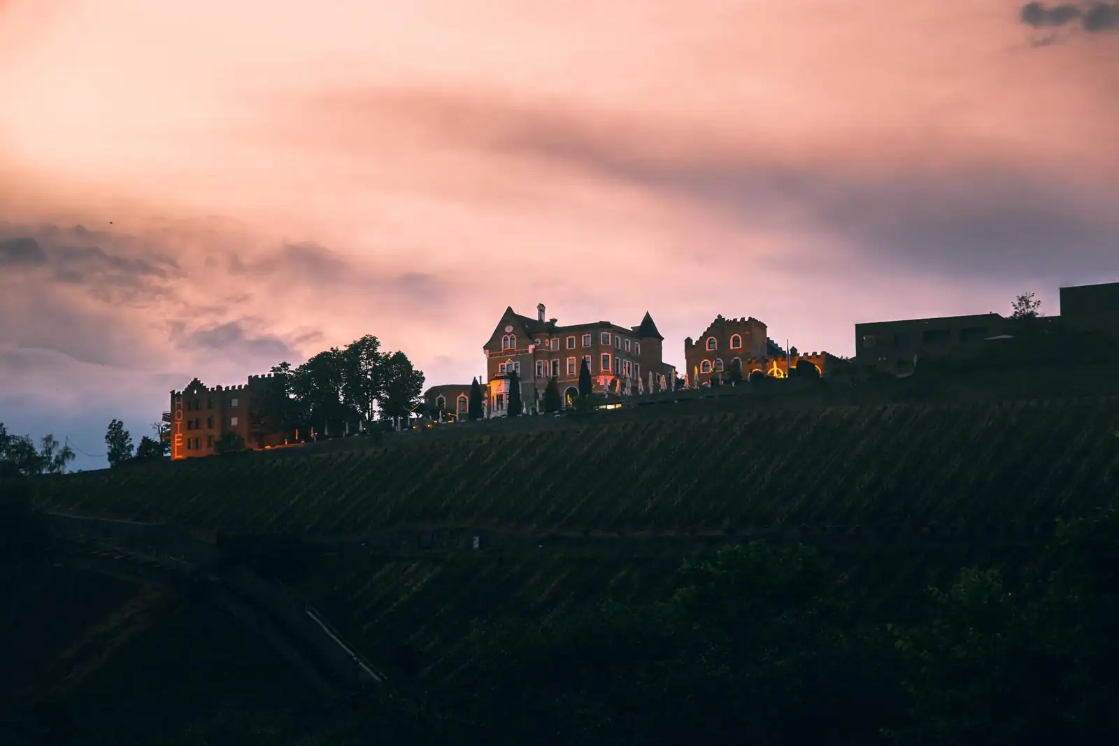 Hôtel sur une colline surplombant des rangs de vigne au coucher du soleil