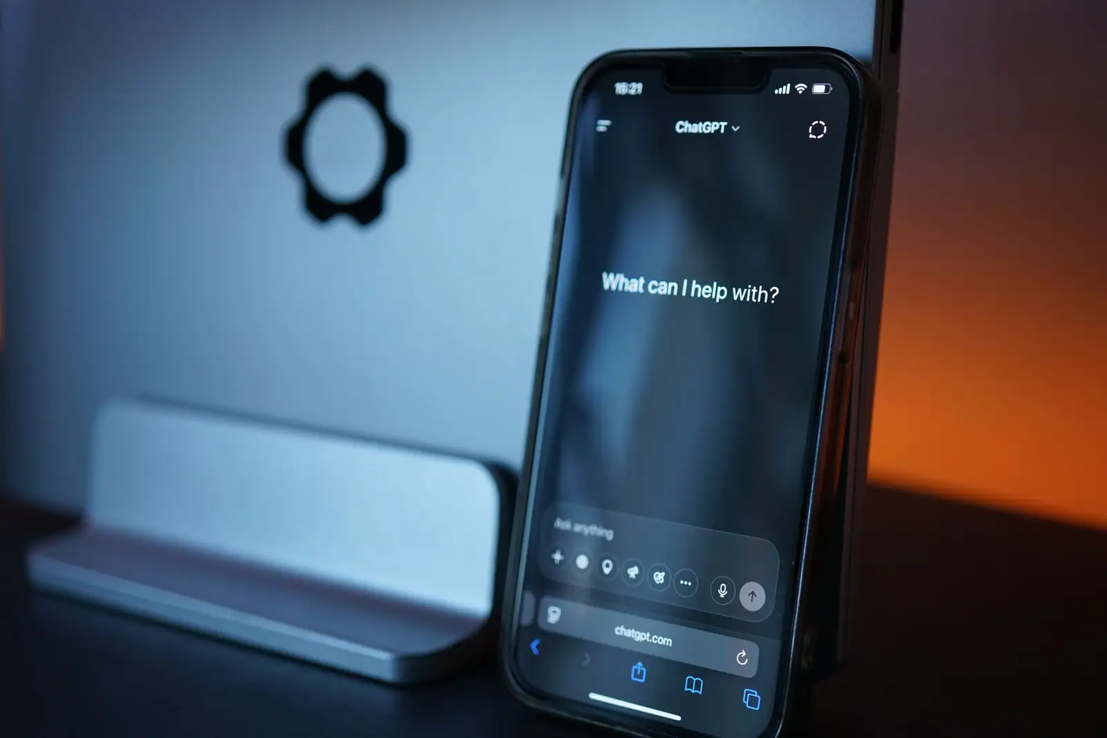 Smartphone affichant l'interface d'un assistant conversationnel d'intelligence artificielle, dans une ambiance sombre.