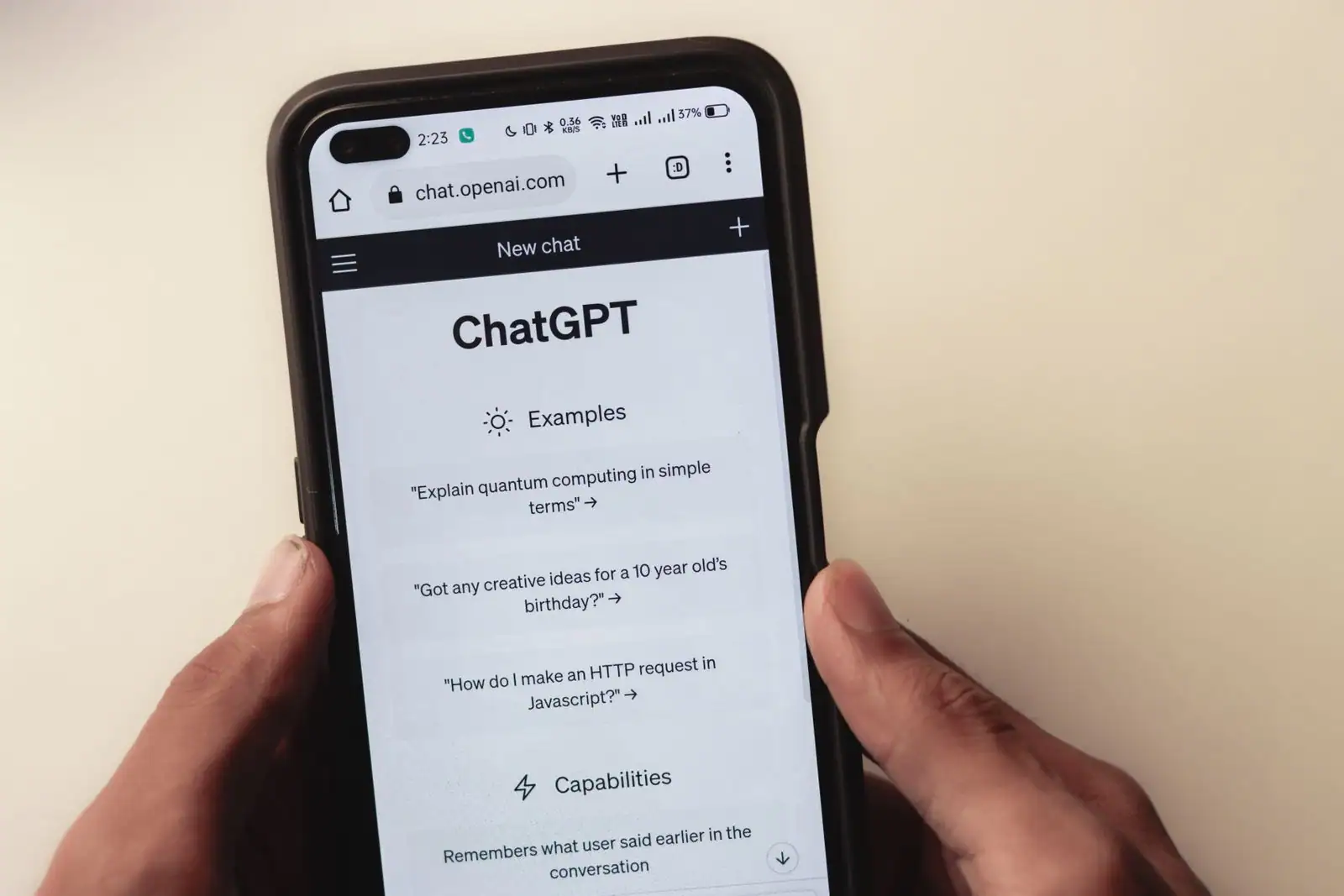 Smartphone tenu en main affichant l'écran d'accueil de ChatGPT