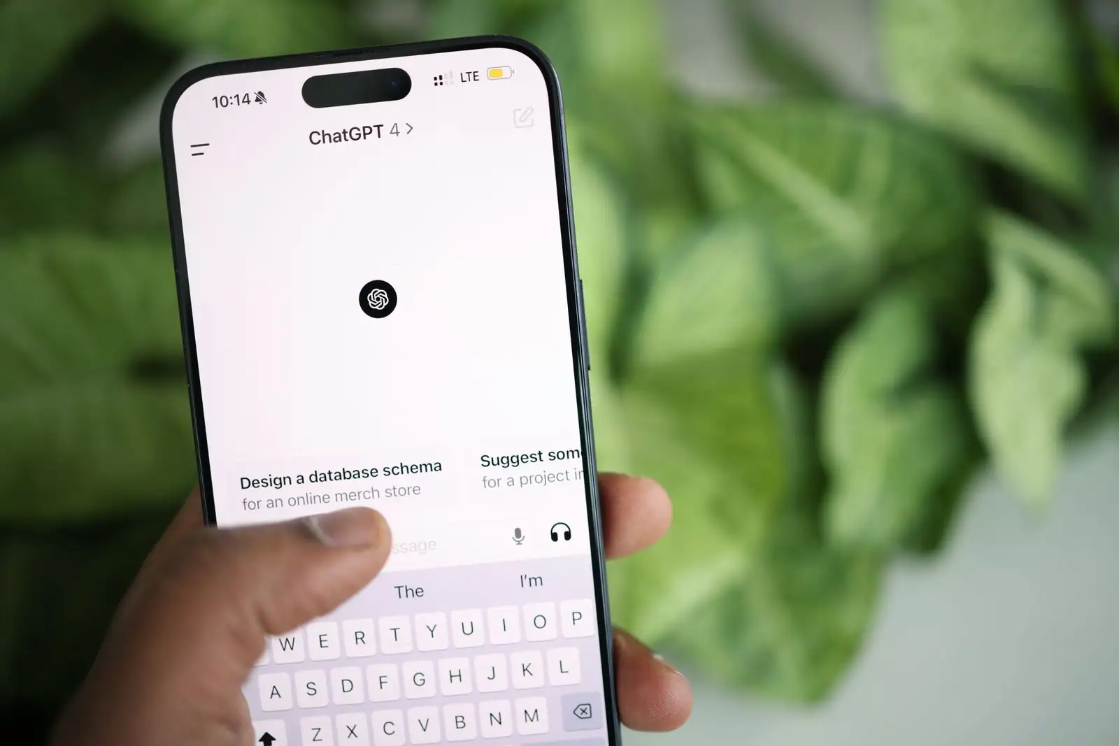 Smartphone tenu en main affichant l'application ChatGPT ouverte à l'écran