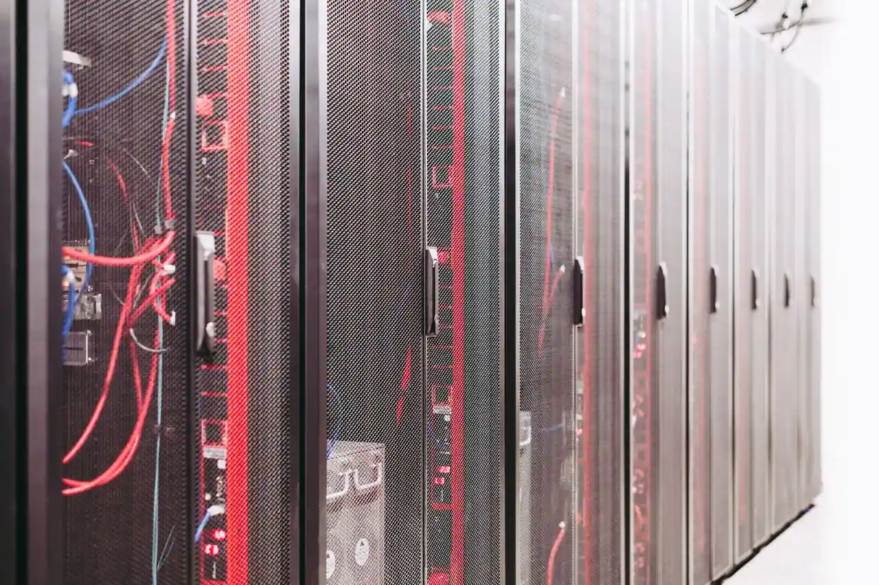 Rangée de baies de serveurs informatiques aux câbles rouges et bleus, dans un centre de données.