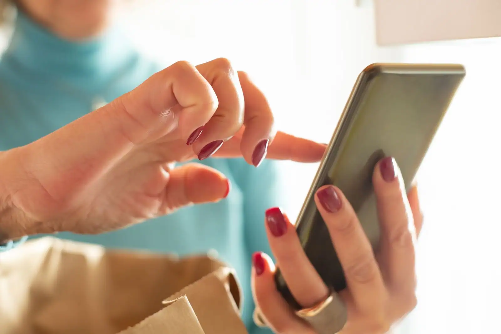 Gros plan sur les mains d'une personne faisant défiler l'écran de son smartphone