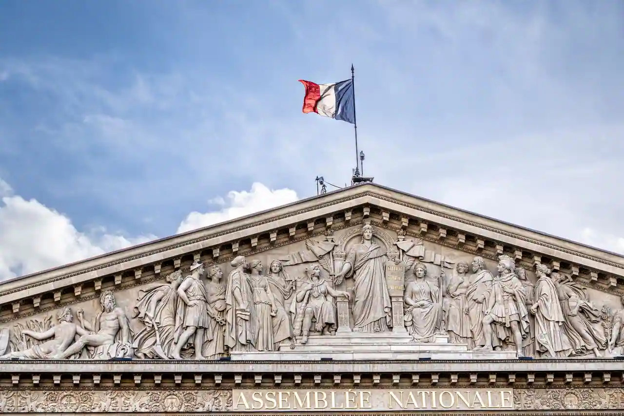 Fronton sculpté de l'Assemblée nationale (Palais Bourbon) surmonté du drapeau tricolore, à Paris