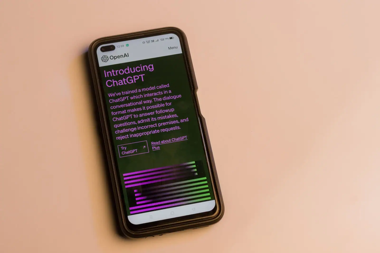 Smartphone posé sur une table affichant la page de présentation de ChatGPT par OpenAI
