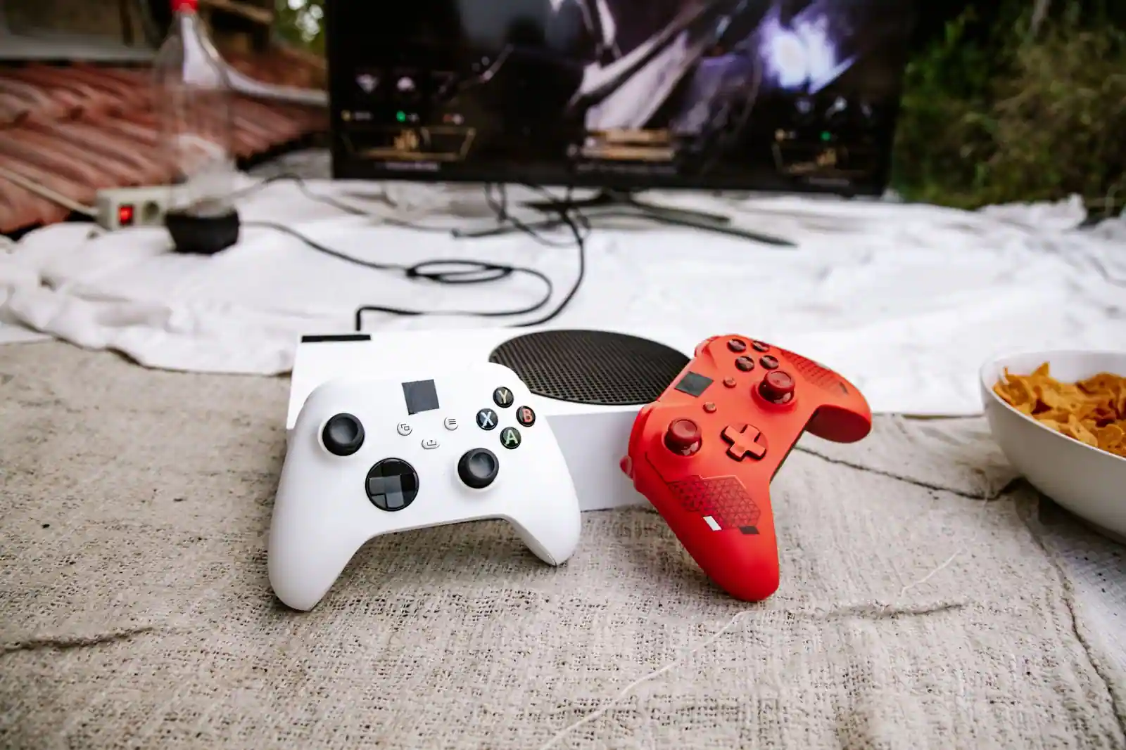 Deux manettes de jeu et une console posées devant un téléviseur affichant un jeu
