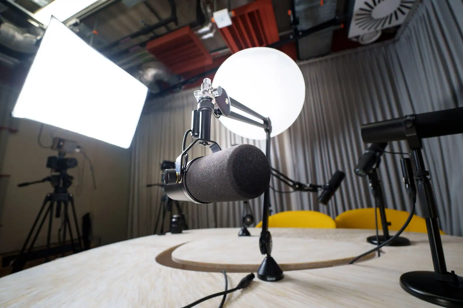 Deux micros de studio sur une table dans un plateau de talk-show éclairé pour un enregistrement