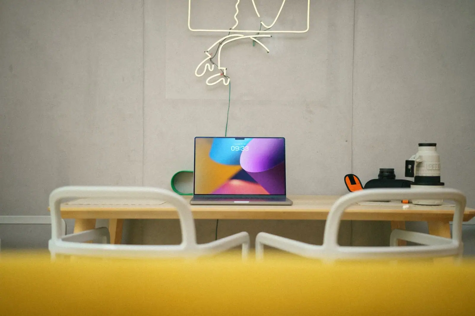 Ordinateur portable posé sur une table, affichant une composition numérique colorée à l'écran