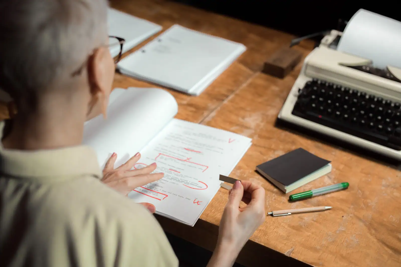 Relecture d'un texte imprimé annoté au stylo rouge, corrections portées à la main dans les marges