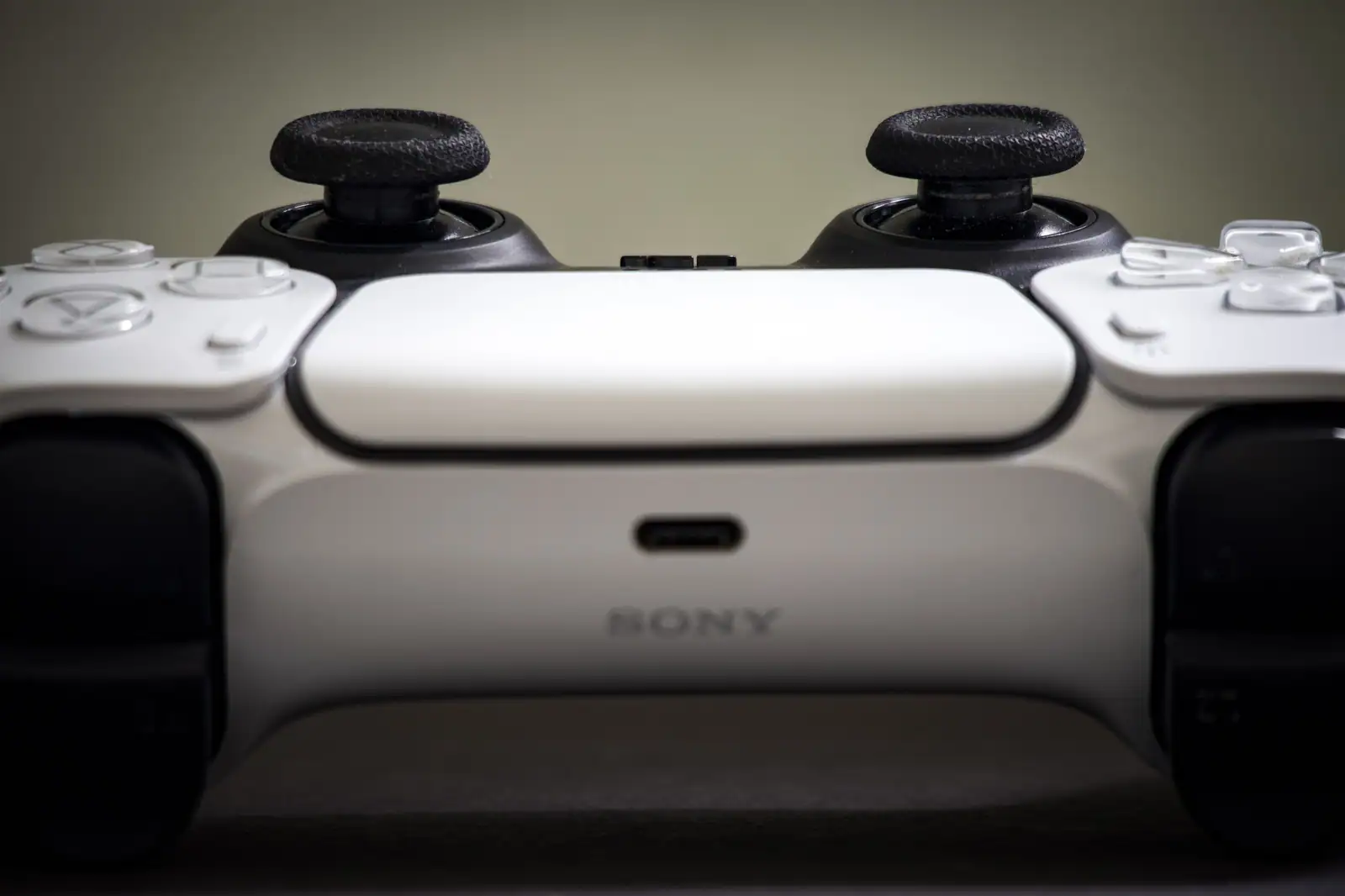 Manette DualSense blanche de PlayStation 5 vue de près, le logo Sony lisible sur la coque