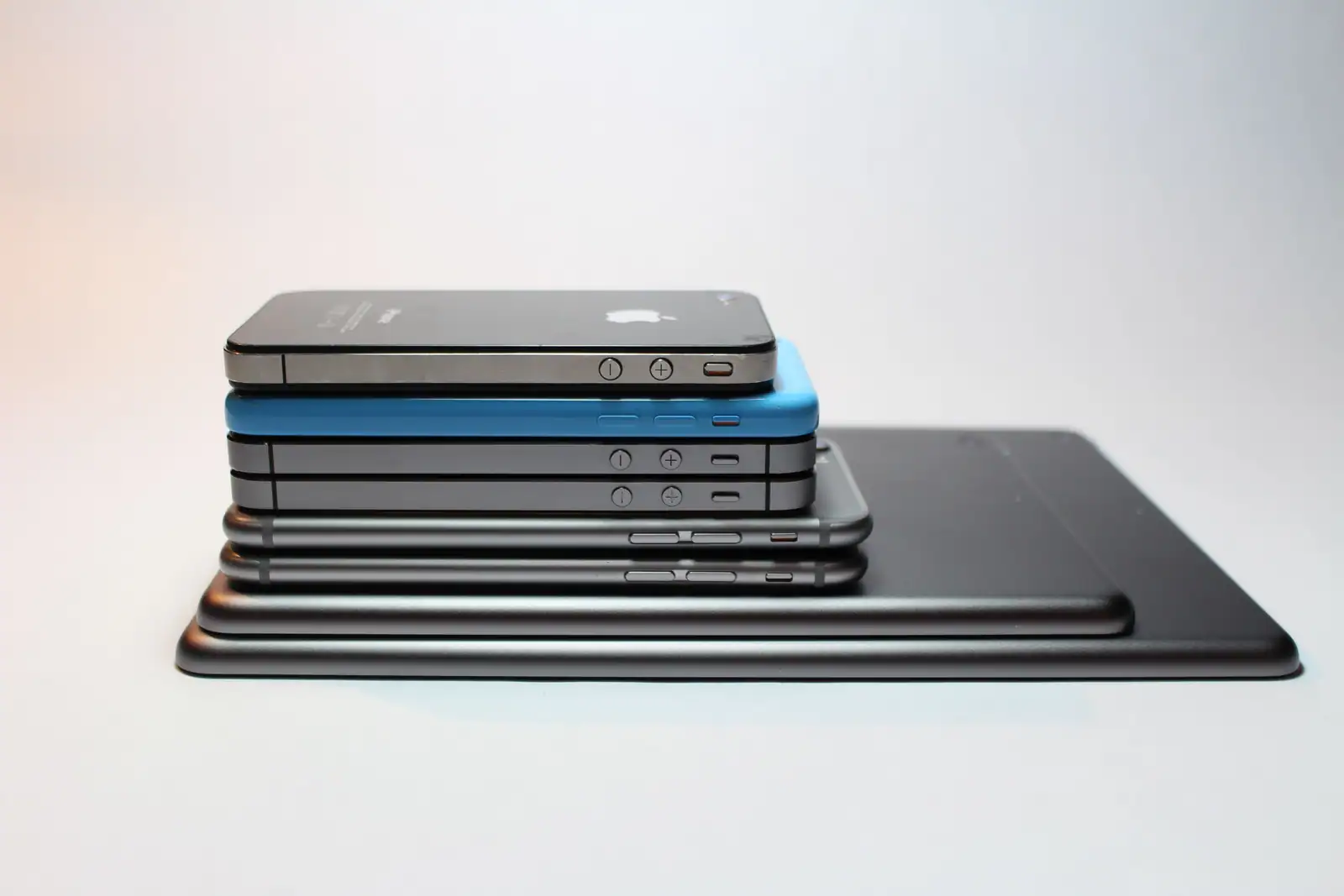 Plusieurs générations de smartphones empilées les unes sur les autres, posées sur une tablette.